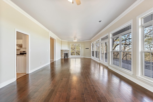 unfurnished living room featuring dark hardwood / wood-style floors, ceiling fan, a fireplace, and a wealth of natural light