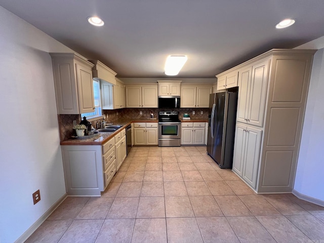 kitchen with tasteful backsplash, stainless steel appliances, sink, and light tile patterned floors