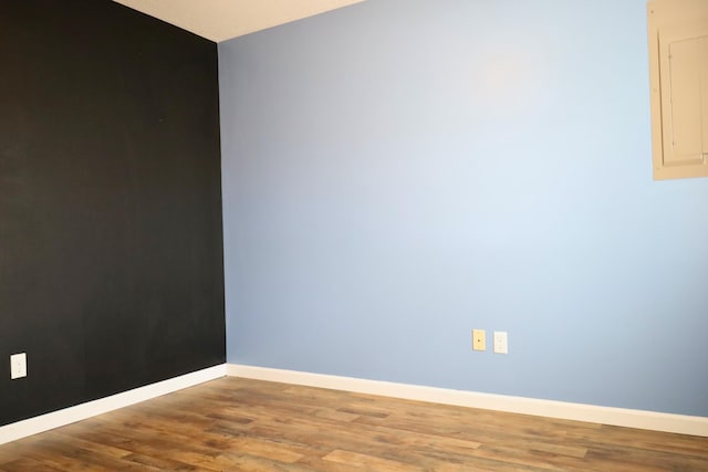 empty room featuring wood-type flooring and electric panel