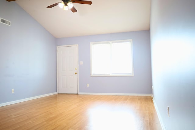 spare room with ceiling fan, vaulted ceiling, and light wood-type flooring