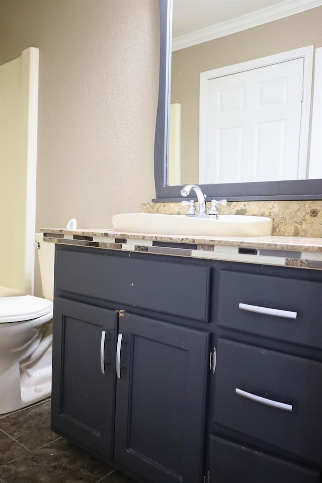 bathroom featuring vanity, ornamental molding, and toilet