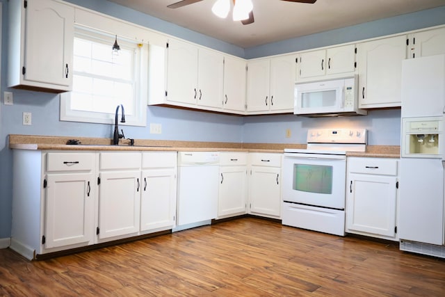 kitchen featuring sink, hardwood / wood-style floors, white cabinets, and white appliances