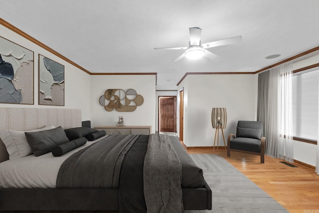 bedroom with ornamental molding, ceiling fan, and light wood-type flooring