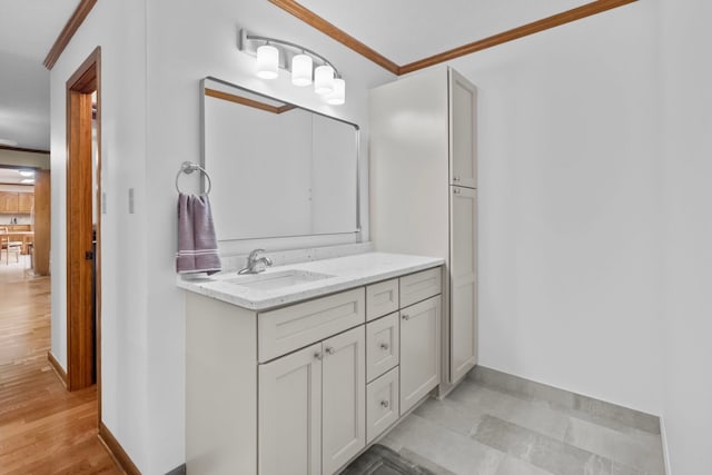 bathroom with hardwood / wood-style flooring, ornamental molding, and vanity