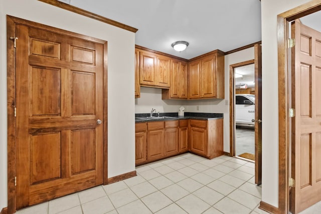 kitchen featuring ornamental molding, sink, and light tile patterned floors