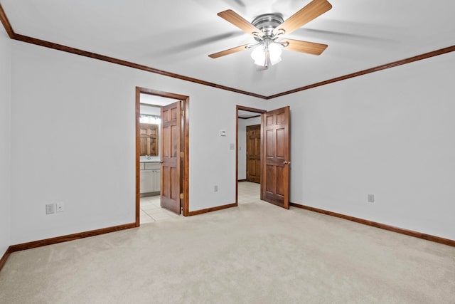 unfurnished bedroom featuring crown molding, light colored carpet, ensuite bathroom, and ceiling fan