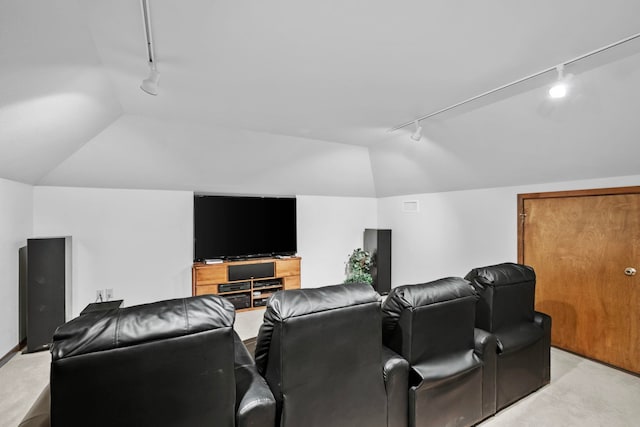 home theater featuring vaulted ceiling, light colored carpet, and rail lighting