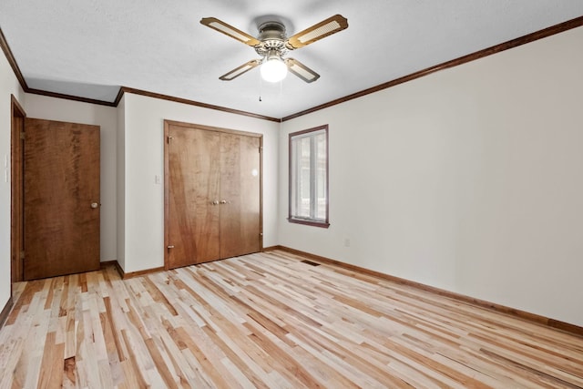 unfurnished bedroom with crown molding, a textured ceiling, a closet, ceiling fan, and light hardwood / wood-style floors