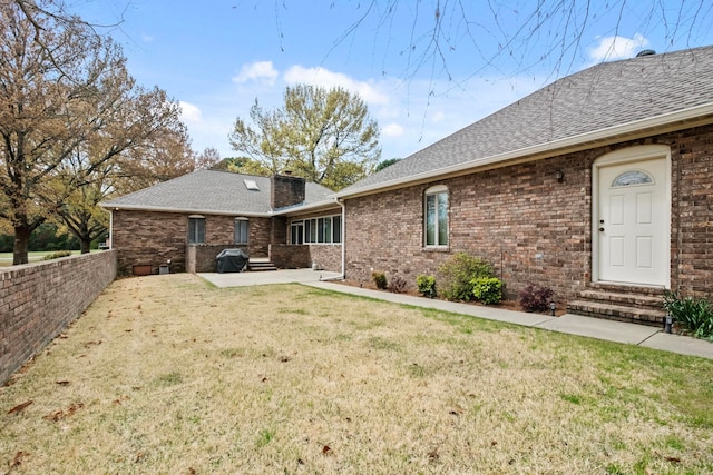 rear view of property featuring a yard and a patio area