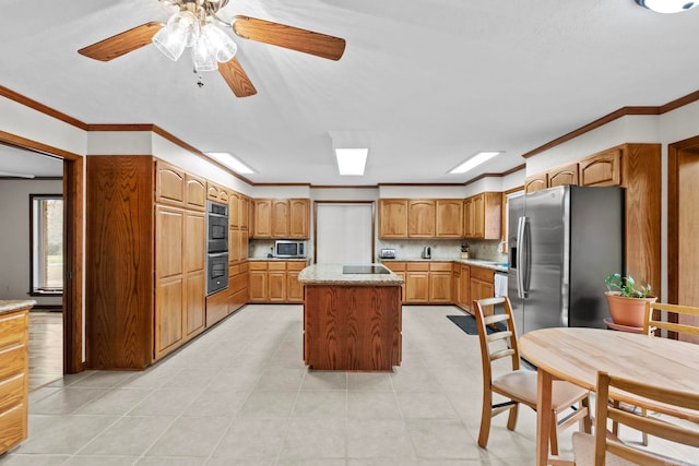 kitchen featuring light tile patterned floors, ornamental molding, stainless steel appliances, and a kitchen island