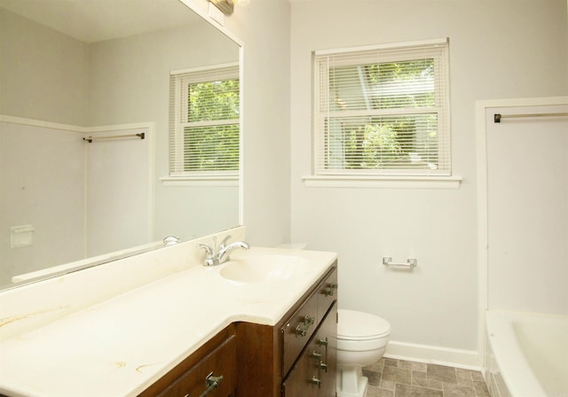 bathroom featuring vanity, a tub, and toilet