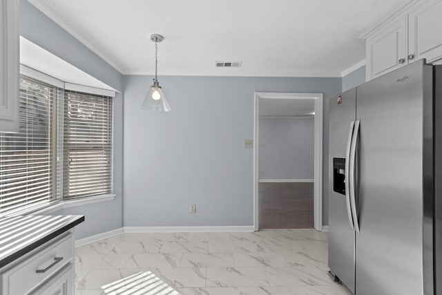 kitchen with stainless steel refrigerator with ice dispenser, ornamental molding, and white cabinets