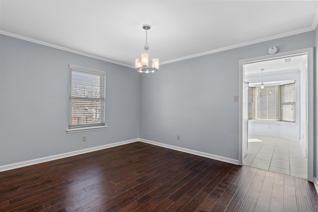 spare room with dark hardwood / wood-style flooring, crown molding, and a chandelier