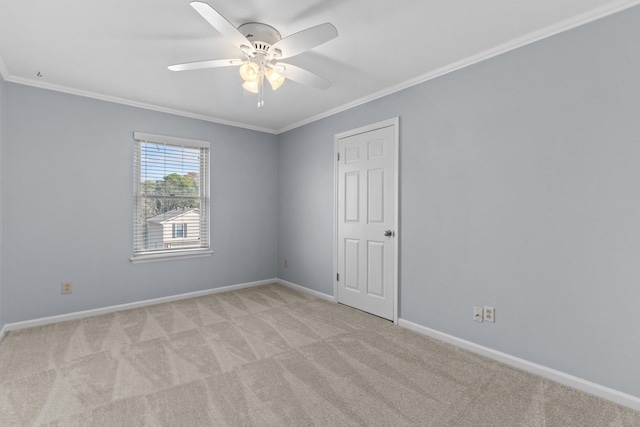 empty room featuring crown molding, light colored carpet, and ceiling fan