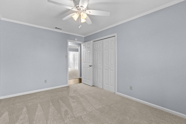 unfurnished bedroom featuring ornamental molding, light carpet, ceiling fan, and a closet