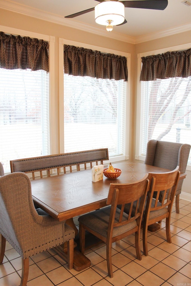 dining space with crown molding, a healthy amount of sunlight, and light tile patterned floors