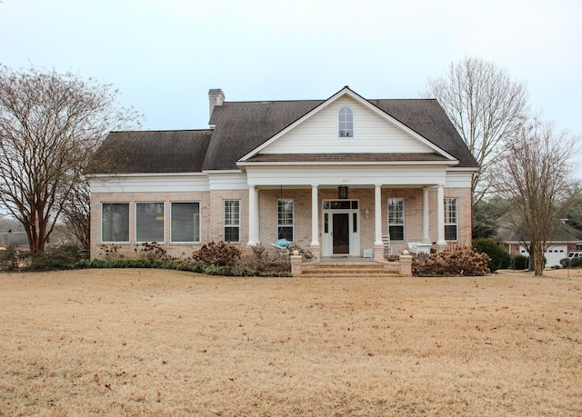 neoclassical home with a front yard and a porch