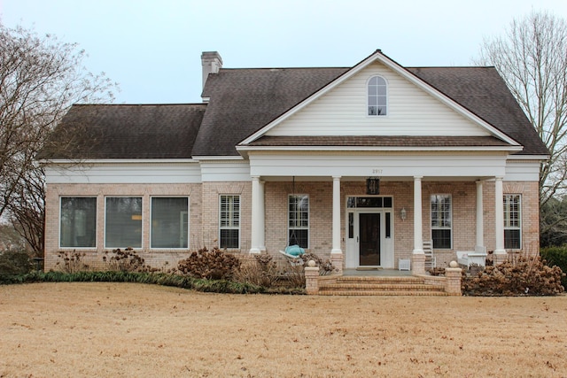 view of front of property featuring covered porch and a front lawn