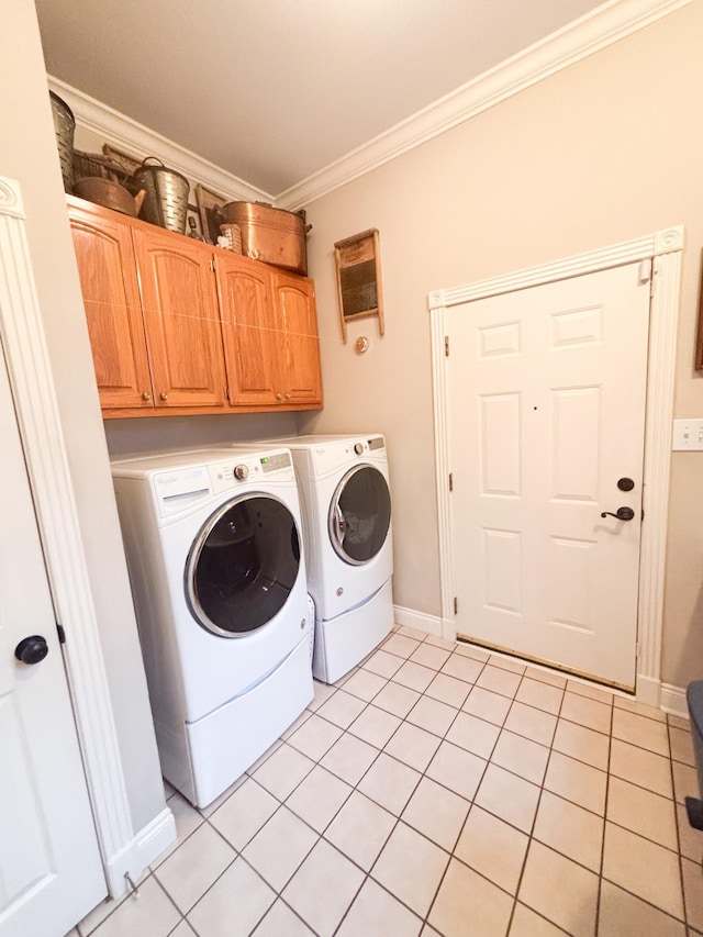 washroom featuring light tile patterned floors, ornamental molding, cabinets, and washing machine and clothes dryer