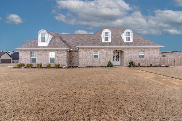 cape cod house with a front lawn