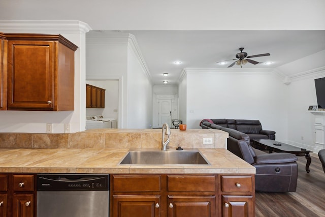 kitchen featuring sink, crown molding, washer and dryer, dark hardwood / wood-style flooring, and dishwasher