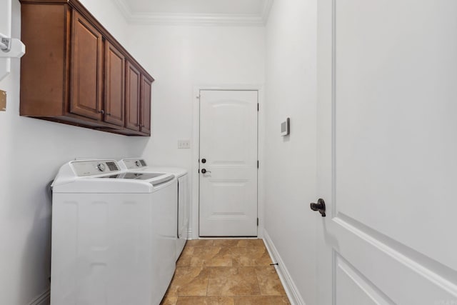 clothes washing area featuring ornamental molding, washing machine and dryer, and cabinets