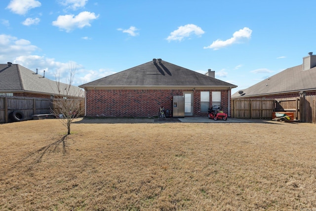 rear view of property with a yard and a patio area