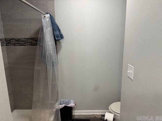 bathroom with a shower with curtain and toilet