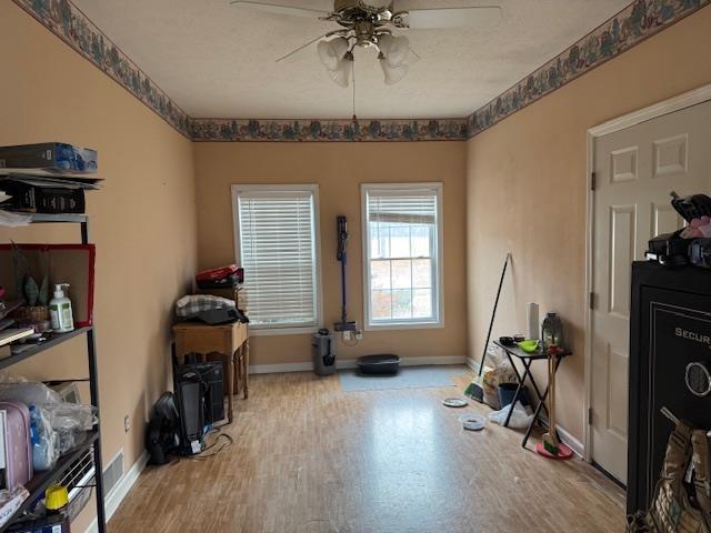 exercise room with ceiling fan and light hardwood / wood-style floors