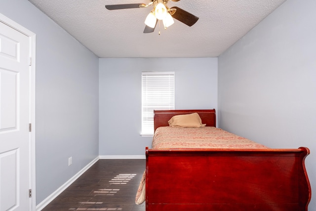 bedroom with dark wood-type flooring, ceiling fan, and a textured ceiling