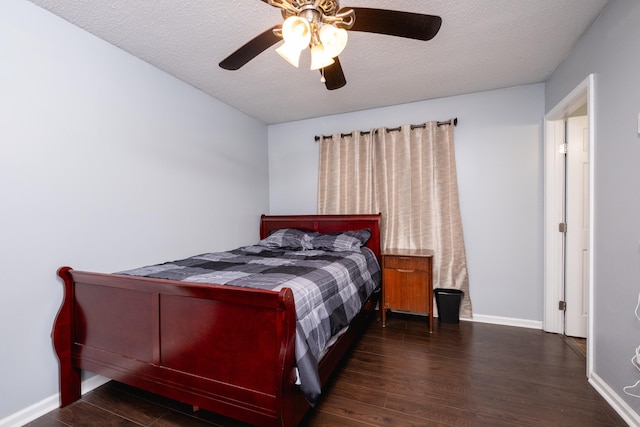 bedroom featuring dark hardwood / wood-style flooring, ceiling fan, and a textured ceiling