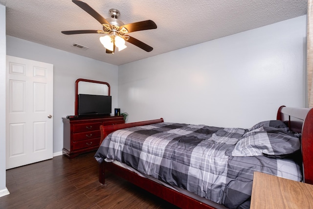 bedroom featuring ceiling fan, dark hardwood / wood-style floors, and a textured ceiling