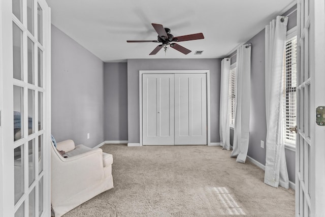 sitting room with visible vents, ceiling fan, baseboards, and carpet