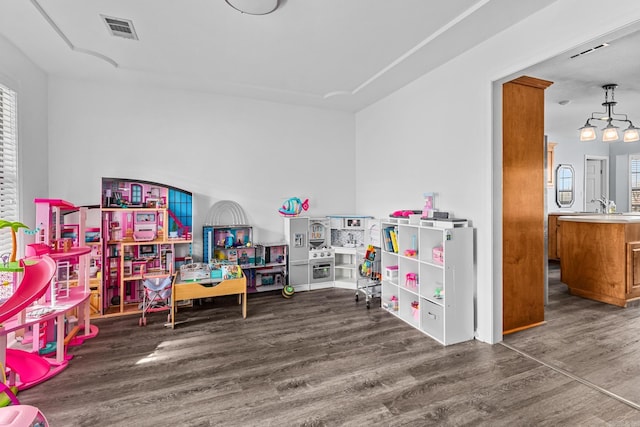 rec room featuring visible vents, a sink, and wood finished floors