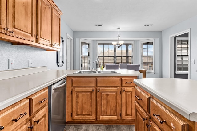 kitchen featuring visible vents, a peninsula, a sink, light countertops, and dishwasher