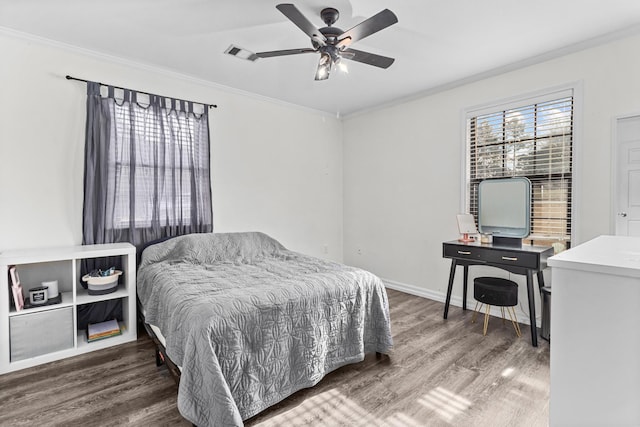 bedroom featuring visible vents, crown molding, ceiling fan, baseboards, and wood finished floors