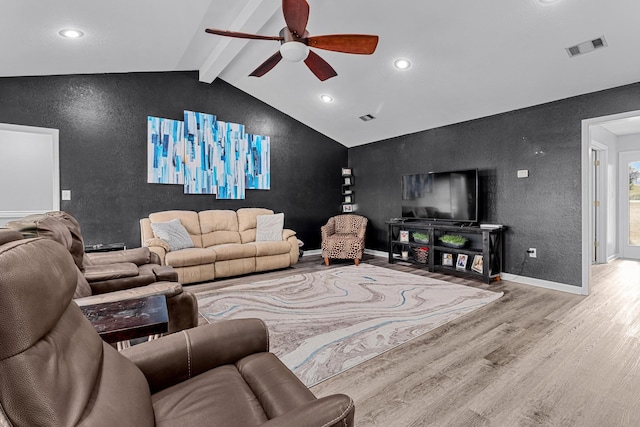 living area featuring visible vents, ceiling fan, wood finished floors, lofted ceiling with beams, and a textured wall