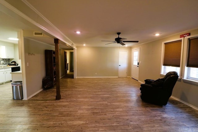 living room featuring crown molding, hardwood / wood-style floors, and a wealth of natural light