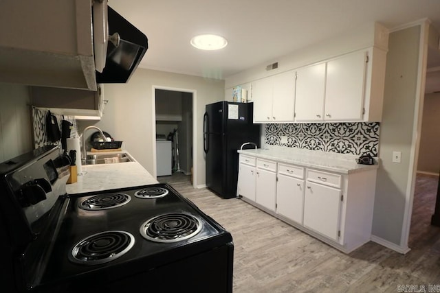 kitchen with white cabinetry, sink, light wood-type flooring, and black appliances