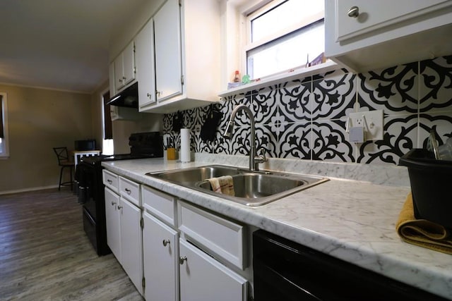 kitchen with white cabinetry, sink, backsplash, hardwood / wood-style flooring, and black appliances