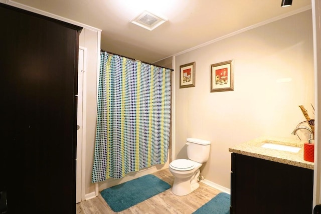 bathroom with vanity, wood-type flooring, ornamental molding, toilet, and walk in shower