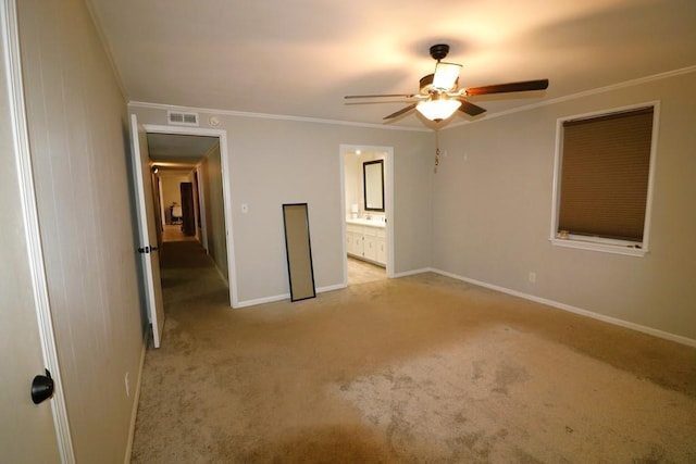 unfurnished bedroom featuring ceiling fan, ornamental molding, ensuite bathroom, and light carpet