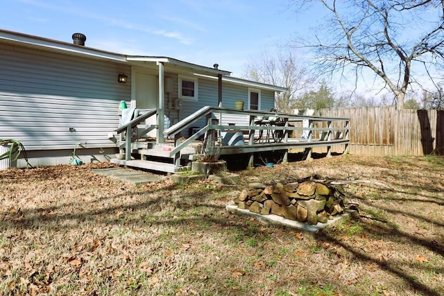 back of house featuring a wooden deck and a lawn