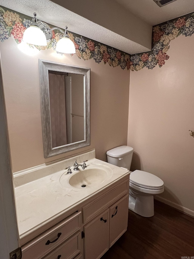 bathroom featuring vanity, hardwood / wood-style floors, and toilet