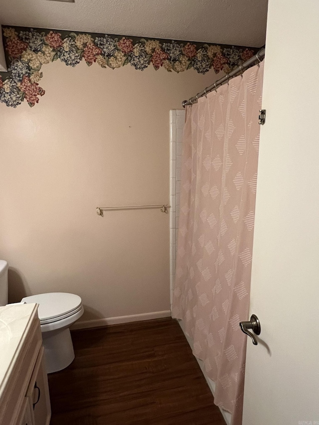 bathroom featuring vanity, hardwood / wood-style floors, a textured ceiling, and toilet