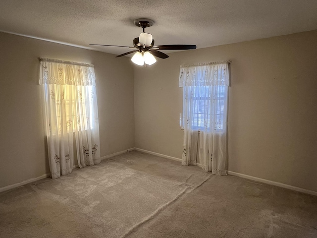 unfurnished room with ceiling fan, light carpet, and a textured ceiling