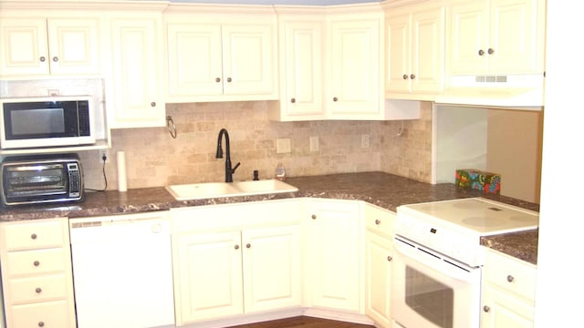 kitchen with sink, white appliances, tasteful backsplash, cream cabinetry, and exhaust hood