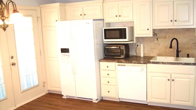 kitchen featuring sink, white appliances, dark wood-type flooring, decorative backsplash, and decorative light fixtures