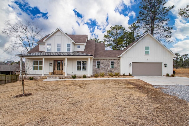 modern inspired farmhouse with a garage, a front yard, and covered porch