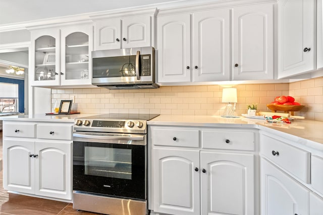 kitchen with appliances with stainless steel finishes, decorative backsplash, and white cabinets